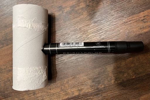 photo of a black prismacolour marker stuck into a hole that's cut into a toiler paper roll